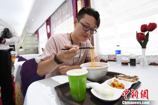 图为旅客在列车上享用正宗牛肉面?！⊙钛廾?摄